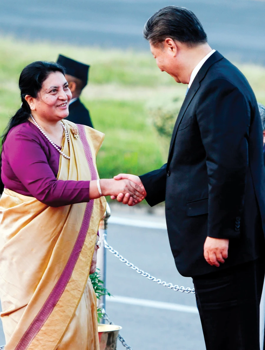 Nepal's President Bidhya Devi Bhandari shakes hands with China's President Xi Jinping during a welcome ceremony at the airport in Kathmandu on Saturday. Xi is making the first state visit by a Chinese leader to Nepal in 23 years following his two days of talks in India. (AFP)