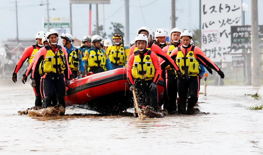 Rescue workers carry a rubber dinghy as they search a flooded area in the aftermath of Typhoon Hagibis, which caused severe floods at the Chikuma River in Nagano Prefecture, Japan, October 14, 2019. (REUTERS)