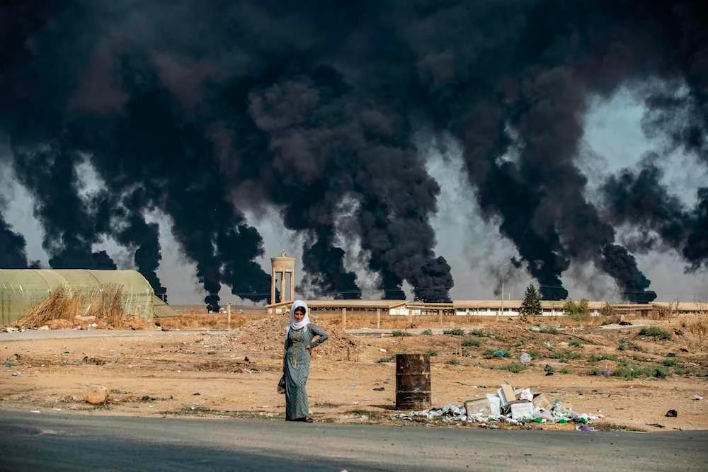 Fires designed to decrease visibility for Turkish jets burn on the outskirts of the town of Tal Tamr near the Syrian Kurdish town of Ras Al-Ain along the border with Turkey in the northeastern Hassakeh province. (AFP)