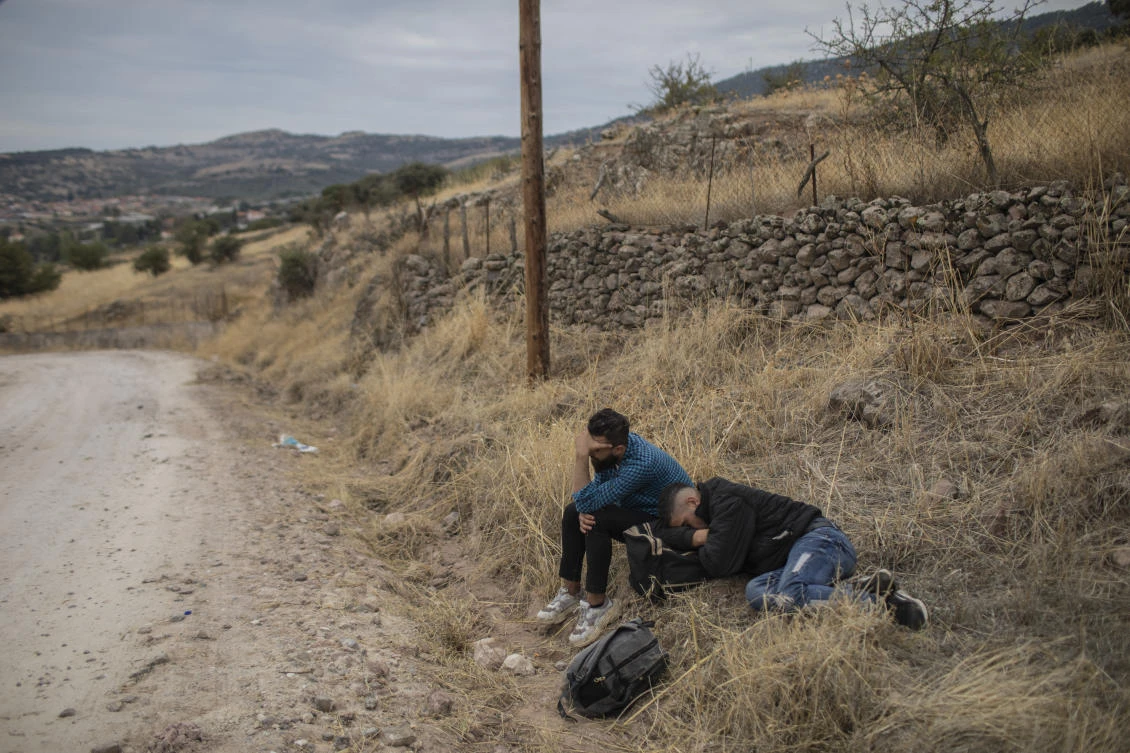 Exhausted men sleep near the town of Madamados after their arrival with other migrants and refugees on a rubber boat from Turkey, at Lesbos Island, Greece. (AP Photo)