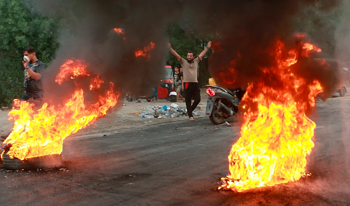 Anti-government protesters set fires and close a street during a demonstration in Baghdad, Iraq. (File/AP)