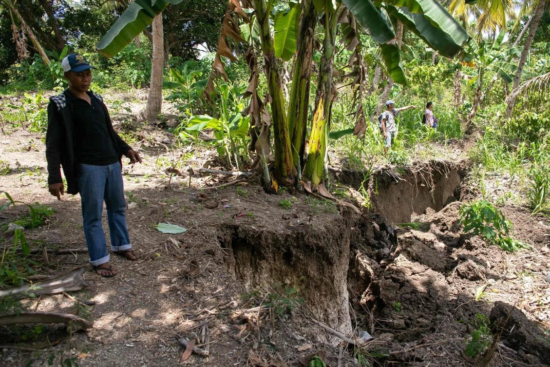 Residents stand near a crack caused by a 6.4 magnitude earthquake near the town of Magsaysay. Three children were among four people killed after the powerful earthquake hit the southern Philippines. (AFP)