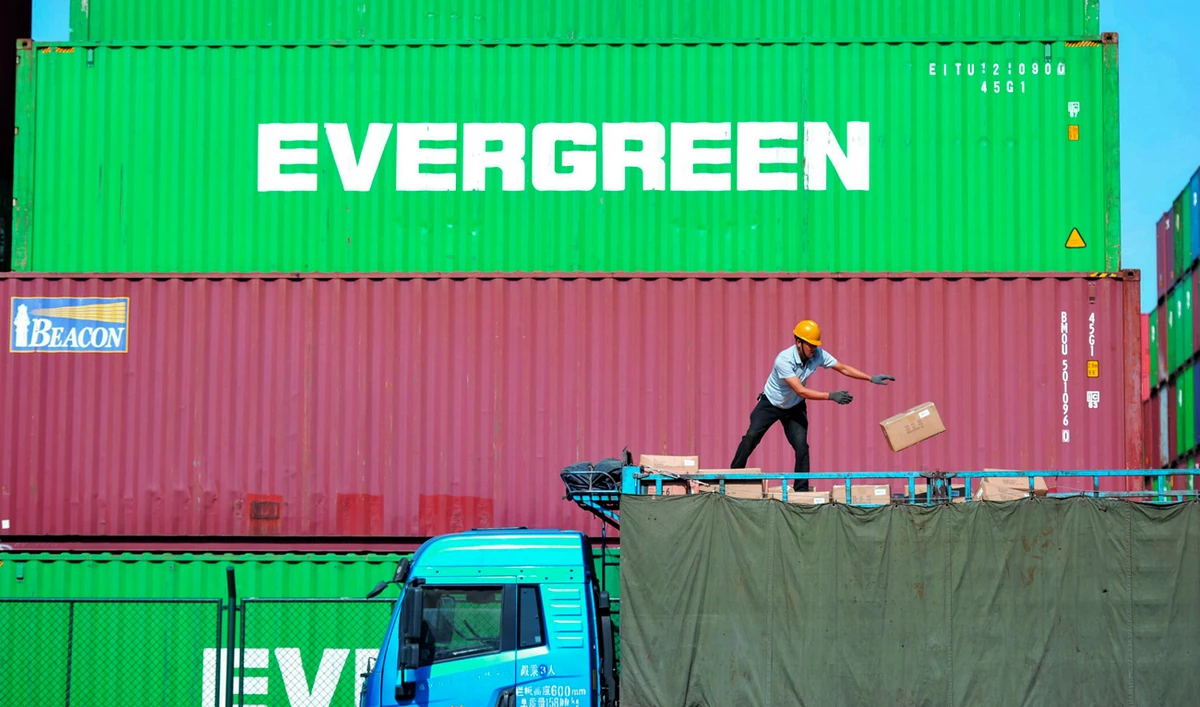 A worker loads imported goods on a truck at a distribution company outside the container port in Qingdao in east China's Shandong province. (Chinatopix via AP)