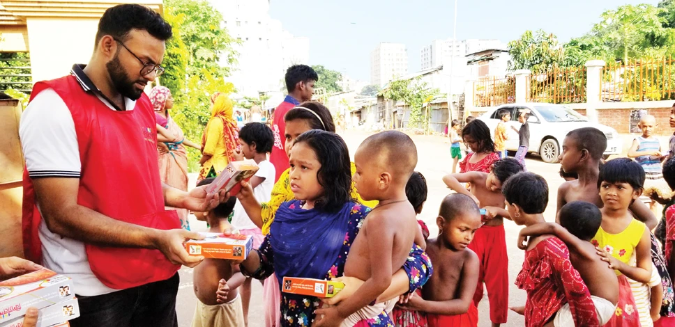 Children gather at a Mirpur site in Dhaka to collect meal packets from Bidyanondo helpers. For many, it will be their only proper food of the day. In the past three years the volunteer group has handed out more than 2.5 million meals. (Supplied photo)