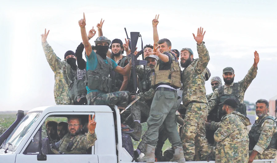 Turkey-backed Syrian rebels drive on top of a truck to cross into Syria, near the border town of Akcakale in Sanliurfa province, Turkey, on Thursday. (Reuters)