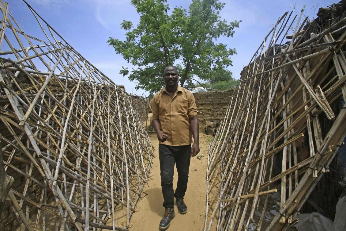 A Sudanese resident of the Kalma camp for displaced people near Niyala, the provincial capital of South Darfur state, walks between makeshift shelters on October 9, 2019. (AFP)