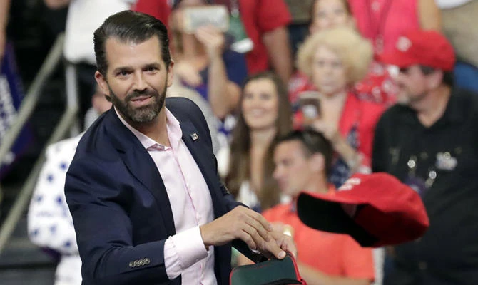 In this June 18, 2019, file photo, Donald Trump Jr. throws hats to supporters at a campaign rally for President Donald Trump in Orlando, Florida. (AP Photo/John Raoux)