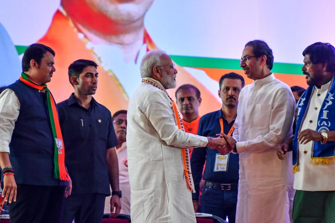 India’s Prime Minister Narendra Modi (C) shakes hands with Hindu right-wing party Shiv Sena Chief Uddhav Thackeray (2R) as they attend a public rally in the run up to the Maharashtra state assembly elections, in Mumbai on October 18, 2019. (File/AFP)