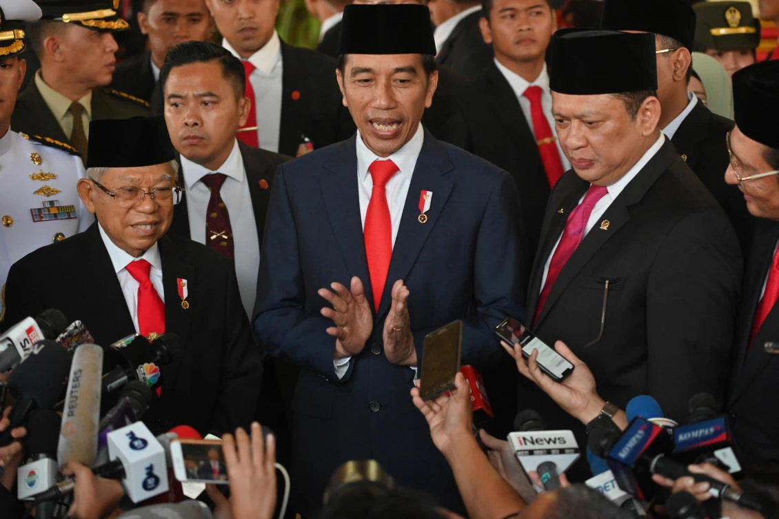 Indonesian President Joko Widodo, center, speaks to journalists next to Vice President Ma’ruf Amin, left, after their inauguration at the parliament building in Jakarta, Indonesia. (AP Photo)
