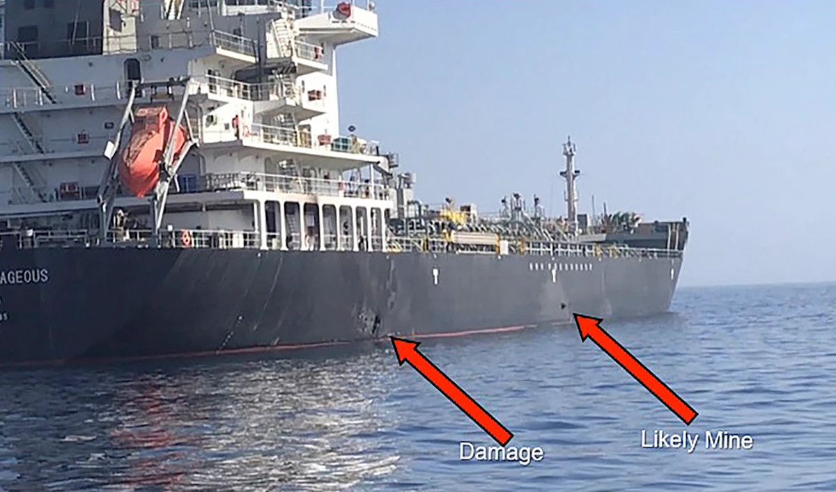 In this Powerpoint slide provided by US Central Command damage from an explosion, left, and a likely limpet mine can be seen on the hull of the civilian vessel M/V Kokuka Courageous in the Gulf of Oman, June 13, 2019, as the guided-missile destroyer USS Bainbridge (DDG 96), not pictured, approaches the damaged ship. (AFP /US NAVY)
