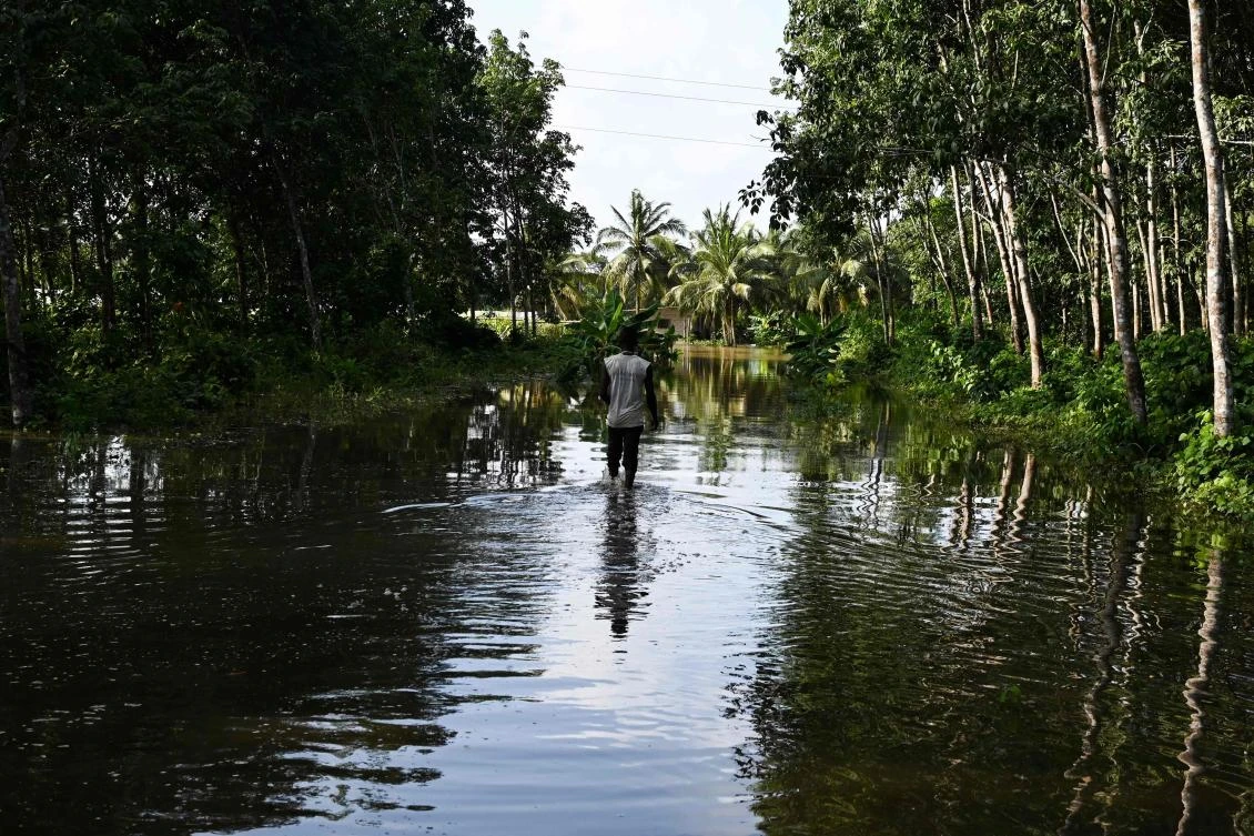 A man walks in front of a flooded farm in the village of Yaou near Bonoua, in southern Ivory Coast on October 17, 2019 after heavy rains. (AFP)