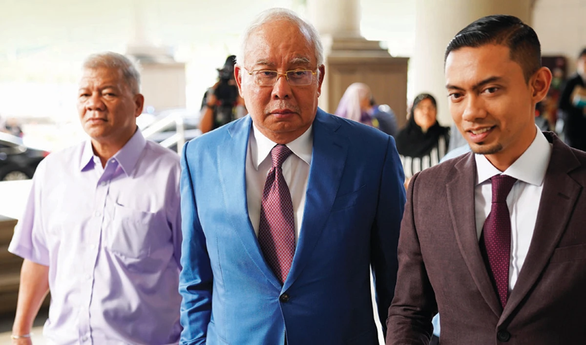 Former Malaysian Prime Minister Najib Razak, center, arrives for his hearing in Kuala Lumpur. Najib is facing 42 charges of corruption, abuse of power and money laundering linked to the multibillion-dollar looting of 1MDB. (AP)
