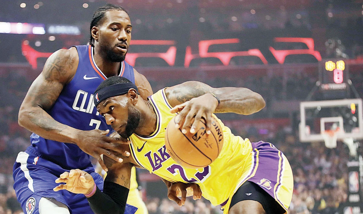 Los Angeles Lakers’ LeBron James, right, is defended by Los Angeles Clippers’ Kawhi Leonard at the first half of an NBA game on Tuesday in Los Angeles. (AP)