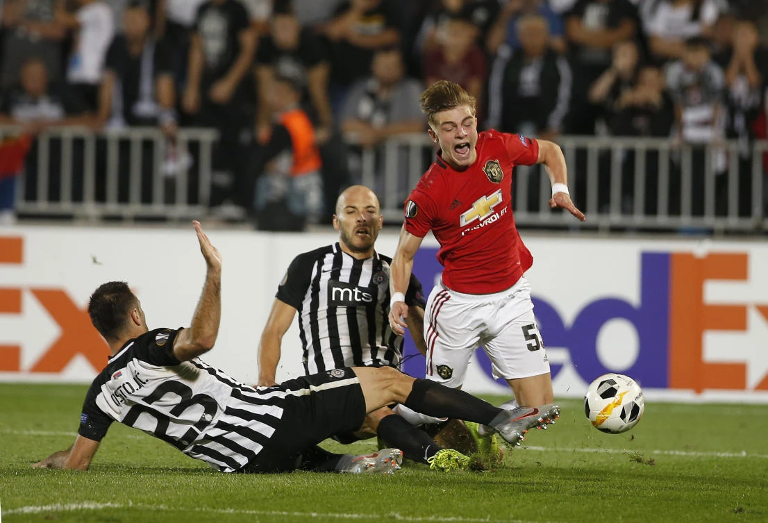 Man United’s Brandon Williams, right, is fouled by Partizan’s Bojan Ostojic, left, and Zoran Tosic, 2nd left, during their Europa League group L soccer match at the Partizan stadium in Belgrade. (AP Photo)