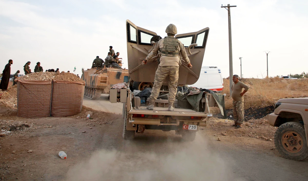 Turkish troops and Turkey-backed Syrian fighters gather near the village of Qirata on the outskirts of the northern city of Manbij near the Turkish border, on October 14, 2019. (AFP)