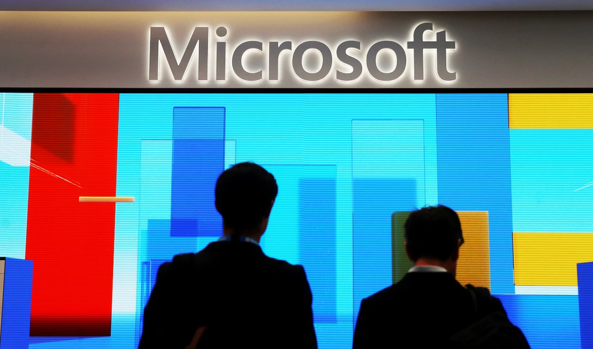 Visitors stand in front of a display screen at a Microsoft store. (File/Reuters)