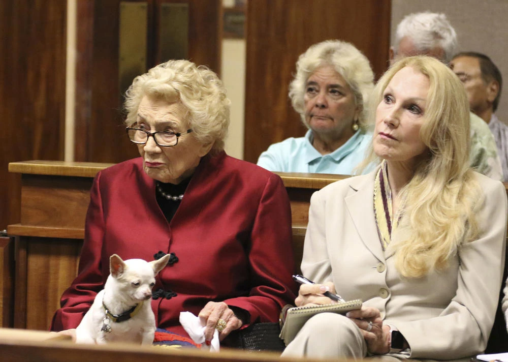 Native Hawaiian heiress Abigail Kawananakoa, left, sits next to her partner, Veronica Gail Worth, while the couple's Chihuahua sits on her lap during a court hearing in Honolulu, on Oct. 25, 2019. (AP Photo/Jennifer Sinco Kelleher)
