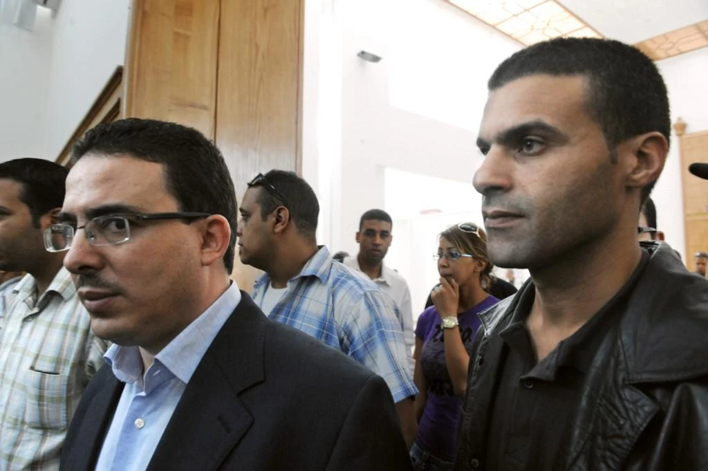 Taoufik Bouachrine, left, of the daily newspaper Akhbar Al-Yaum and caricaturist Khalid Gueddar arrive at the court in Casablanca on October 23, 2009 in earlier trial for alleged disrespect of a member of the royal family. (AFP)