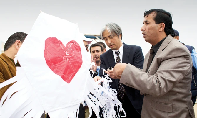 Deputy Representative of Japan in Palestine, Makoto Hirose (C), attends a kite flying event with Palestinian children in the Gaza Strip. (AFP)