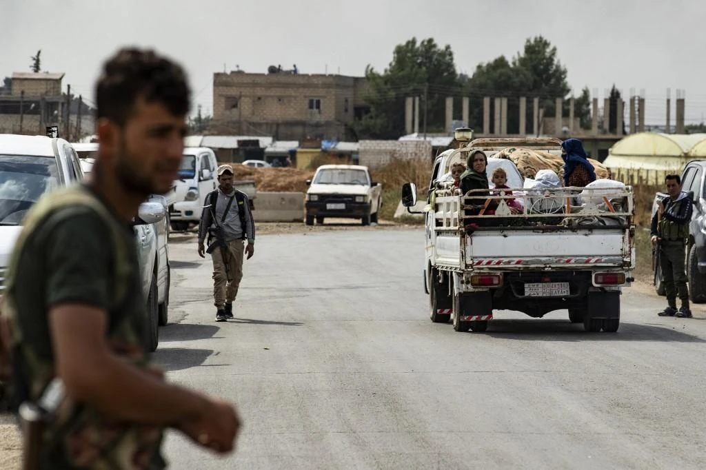 Syrians flee the countryside of the northeastern Syrian town of Ras al-Ain on the Turkish border, toward the west to the town of Tal Tamr after the attacks. (File/AFP)