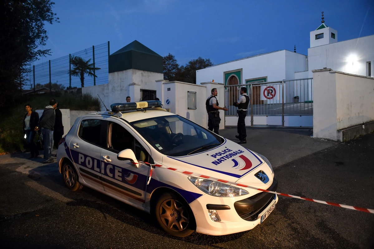 French police officers and people stand in front of the Mosque of Bayonne, southwestern France, on Monday, after two people were injured in a shooting. (AFP)