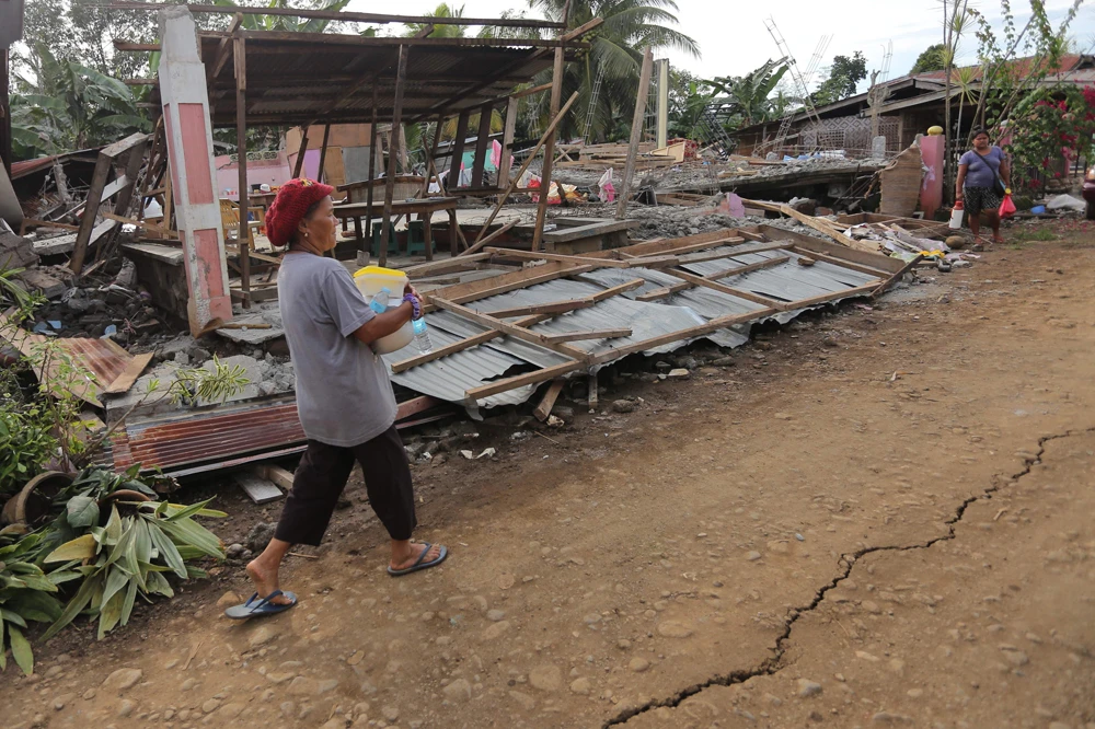 A resident walks past destroyed houses after a 6.6-magnitude earthquake hit Tulunan town, North Cotabato province, on the southern island of Mindanao. (AFP)