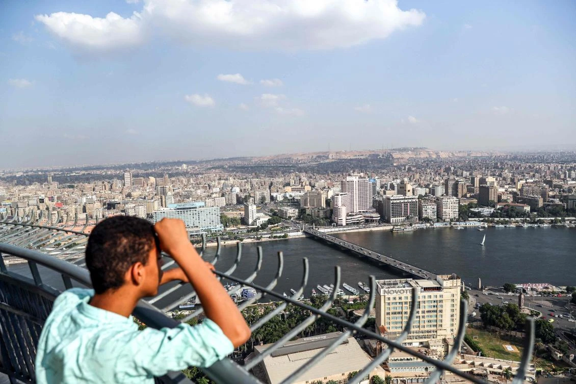 A boy looks from the observation deck of the Cairo Tower in the centre of the Egyptian capital on October 23, 2019, at a view of the Nile river flowing through the city between the central downtown (background) and Zamalek districts (foreground). (AFP)
