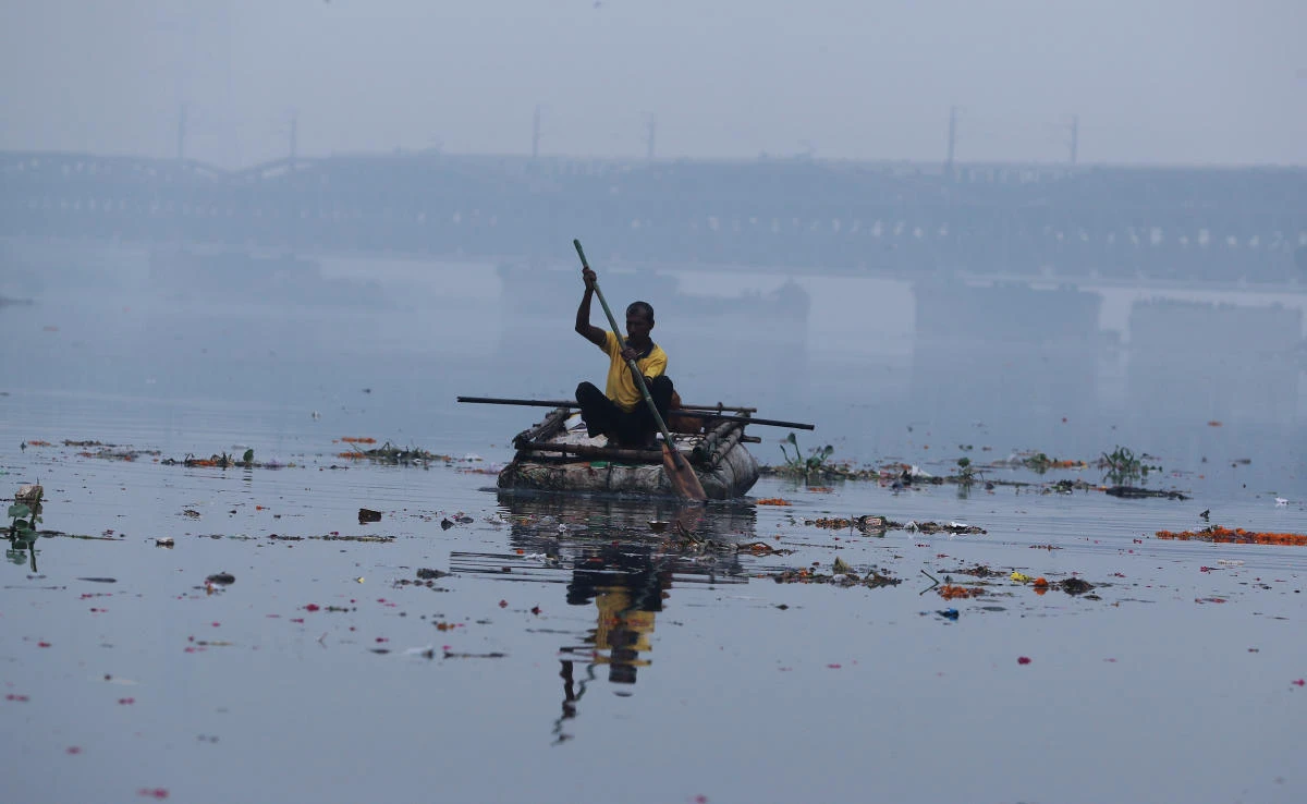 A man paddles a home-made boat across Yamuna river on a smoggy afternoon in the old quarters of Delhi, India, October 30, 2019. (Reuters)