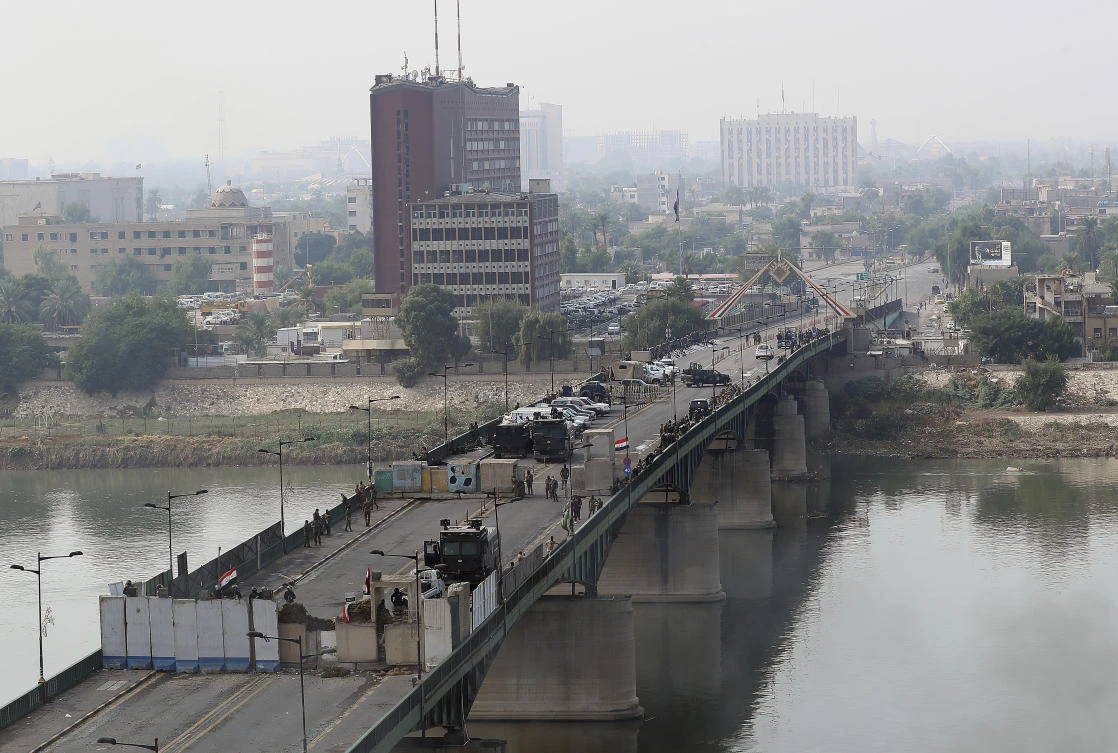 Security forces fire tear gas and close the bridge leading to the Green Zone in Baghdad Wednesday. (AP)