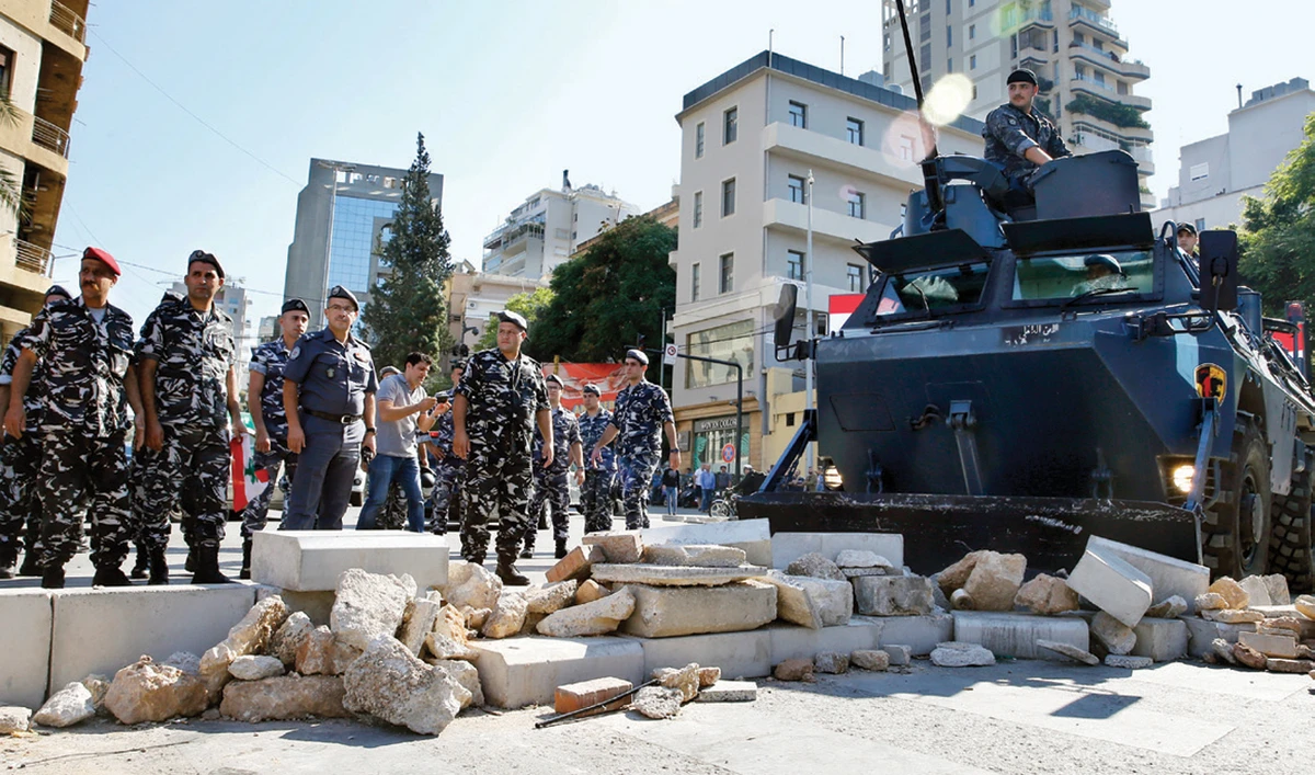 Police remove stones used by protesters to block a main road in Beirut. (AP)