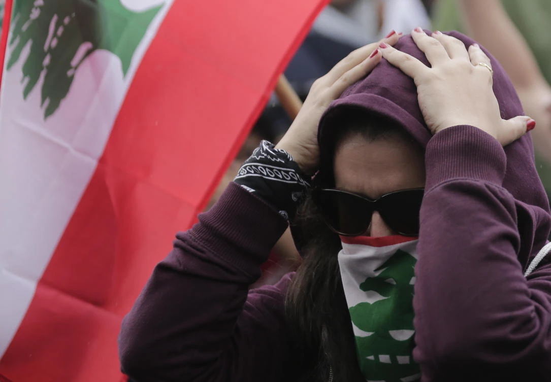 Anti-government protesters shout slogans against Lebanon's President Michel Aoun as they listen on a speaker while he addressees the nation during a protest in the town of Jal el-Dib north of Beirut, Lebanon, Thursday, Oct. 24, 2019. (AP)