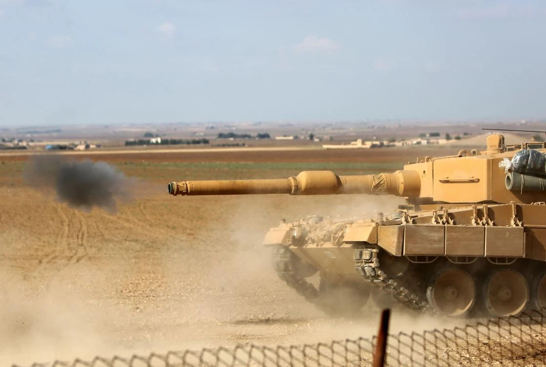 A Turkish Leopard 2 tank fires its gun during clashes between Syrian regime forces, and Turkish forces, 15kms east of the northeastern town of Ras Al-Ein, on October 30, 2019. (AFP)