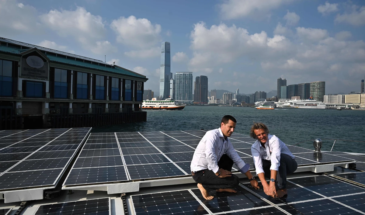 Crew members pose beside solar panels on the top deck of the Race for Water catamaran, the world’s largest maritime vessel to be powered solely by renewable energies. The vessel docked at the public pier in Hong Kong’s Central district on Oct. 25 on a stopover as part of a five-year round-the-world expedition. (AFP)