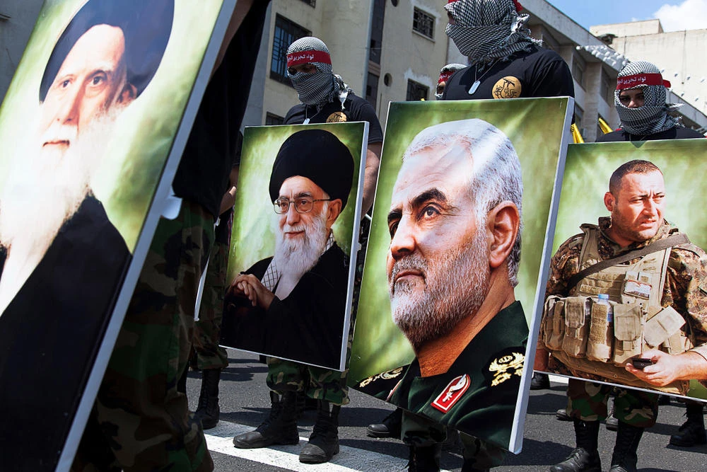 Members of the Iranian "Quds Force" parade in Tehran with portraits of Iranian religious and political leaders. (Shutterstock photo)