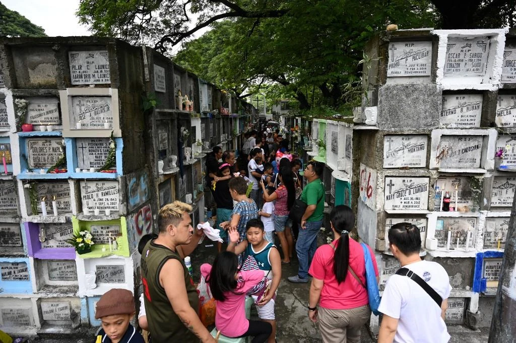 People light candles and pray for their relatives at a cemetery during the annual observance of All Saint’s Day in Manila. (File/AFP)