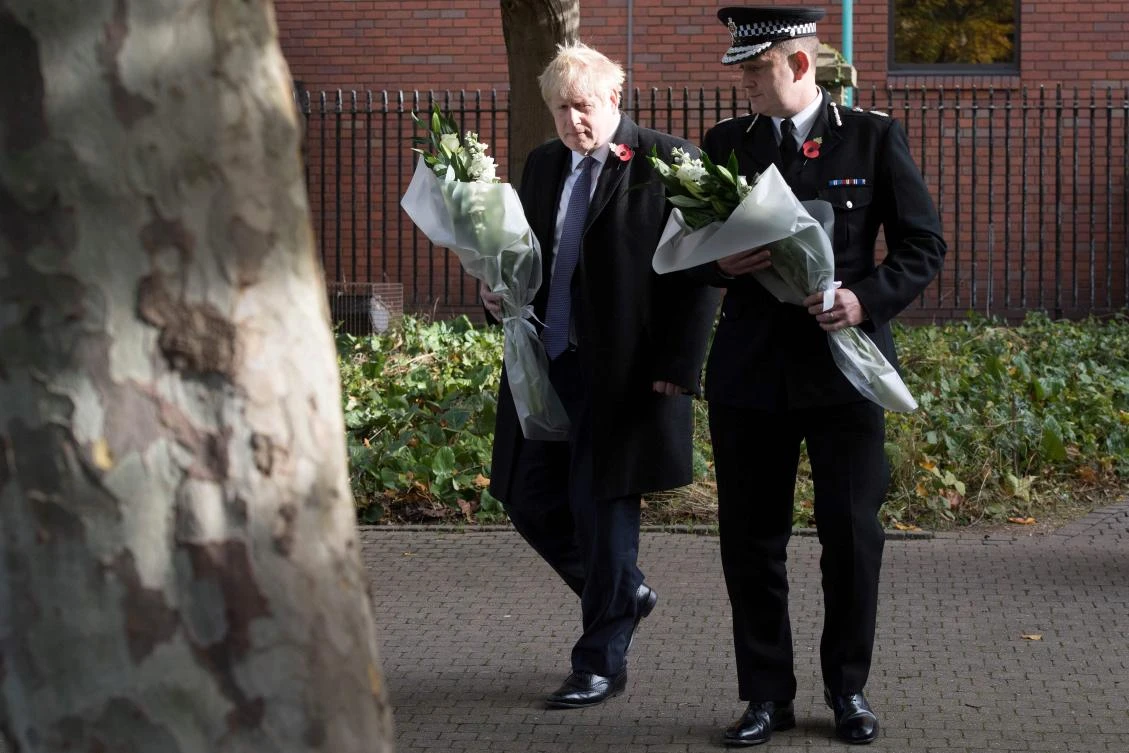 PM Boris Johnson walks with Chief Constable of Essex Police as they prepare to lay flowers, during a visit to Thurrock Council Offices in Thurrock, east of London on October 28, 2019, following the discovery of 39 bodies concealed in a lorry. (AFP)