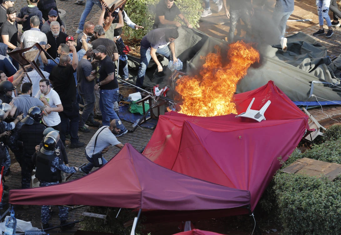 Hezbollah supporters burn tents in the protest camp set up by anti-government protesters near the government palace, in Beirut, Lebanon, Tuesday, Oct. 29, 2019. (AP)
