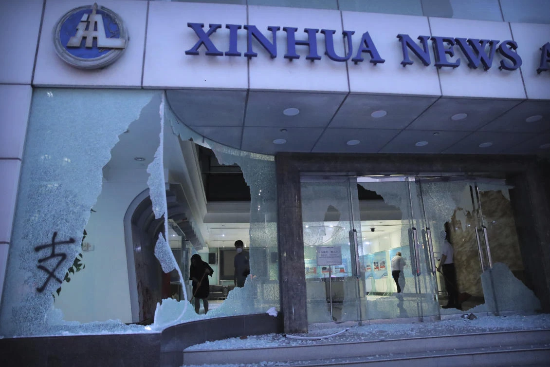 People stand inside the lobby of China's Xinhua News Agency damaged by protesters in Hong Kong, Saturday, Nov. 2, 2019. (AP)