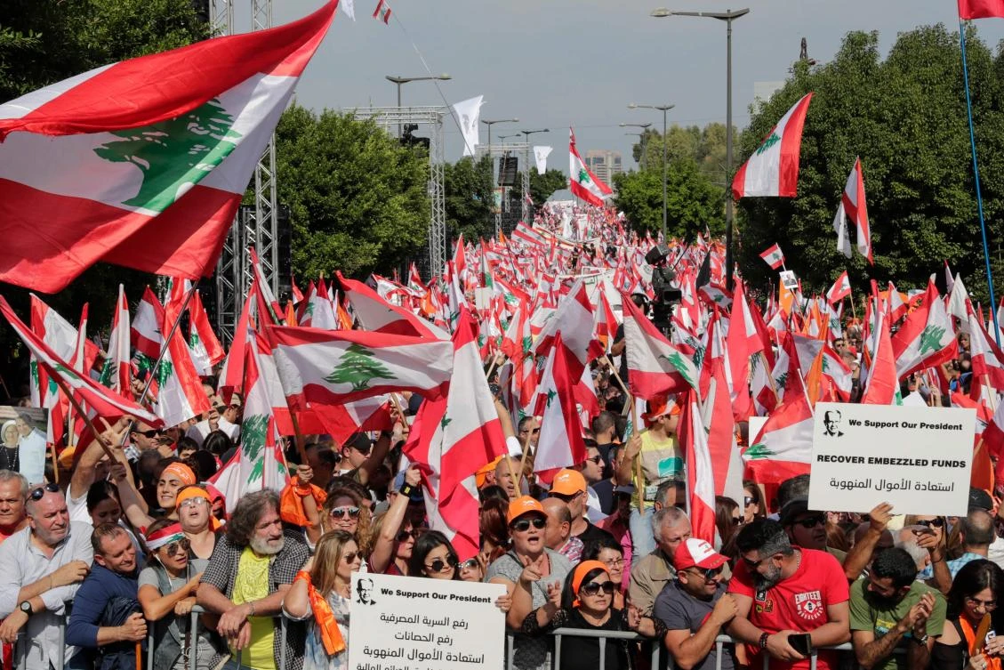 Supporters of Lebanese President Michel Aoun wave national flags and orange-coloured banners during a counter-protest near the presidential palace in Baabda on November 3, 2019. (File/AFP)