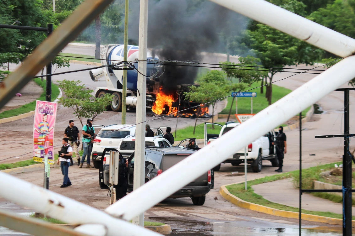 Cartel gunmen are seen near a burning truck during clashes with federal forces following the detention of Ovidio Guzman, in Culiacan, Sinaloa state, Mexico October 17, 2019. (Reuters)
