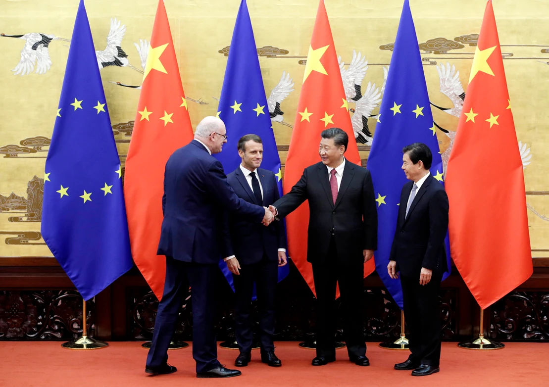 EU Trade Commissioner-designate Phil Hogan, left, shakes hands with Chinese President Xi Jinping next to French President Emmanuel Macron and Chinese Commerce Minister Zhong Shan at a signing ceremony inside the Great Hall of the People in Beijing on Nov. 6, 2019. (Jason Lee/Pool Photo via AP)