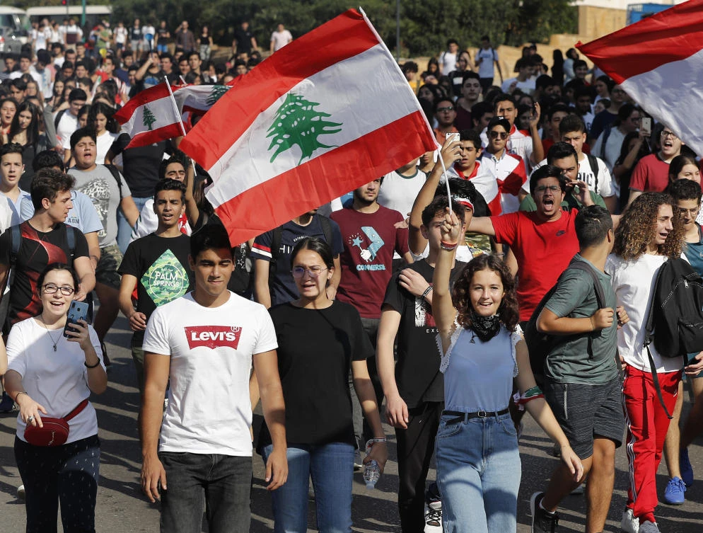 Student protesters wave their national flags and shout slogans, as they protest against the government in front of the education ministry in Beirut, Lebanon, Friday, Nov. 8, 2019. (AP)