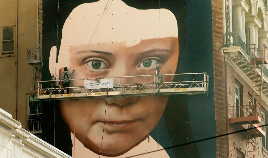 Andres Petreselli paints a mural on the side of a building depicting Swedish teen climate activist Greta Thunberg, Friday, Nov. 8, 2019, in San Francisco. (AP)