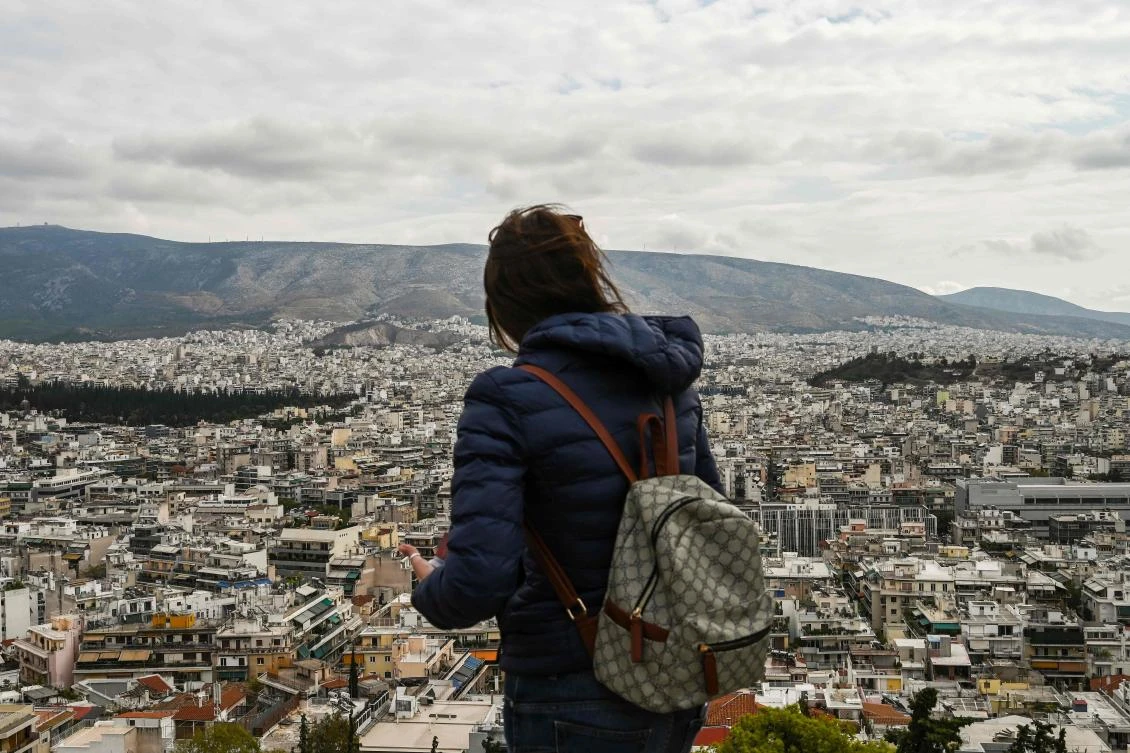 A woman looks at buildings from a hill on November 1, 2019, in Athens as the golden visa arrangement grants non-EU citizens a five-year residence permit in return for investing at least 250,000 euros ($275,000) in Greek real estate. (File/AFP)