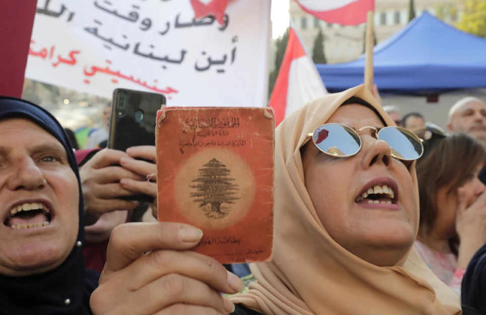 A Lebanese demonstrator holds up an old identity card during a march entitled "My Nationality, My Dignity" in the center of the capital Beirut on Nov. 10, 2019, calling for giving Lebanese women the right to transmit the nationality to their children. (AFP / ANWAR AMRO)