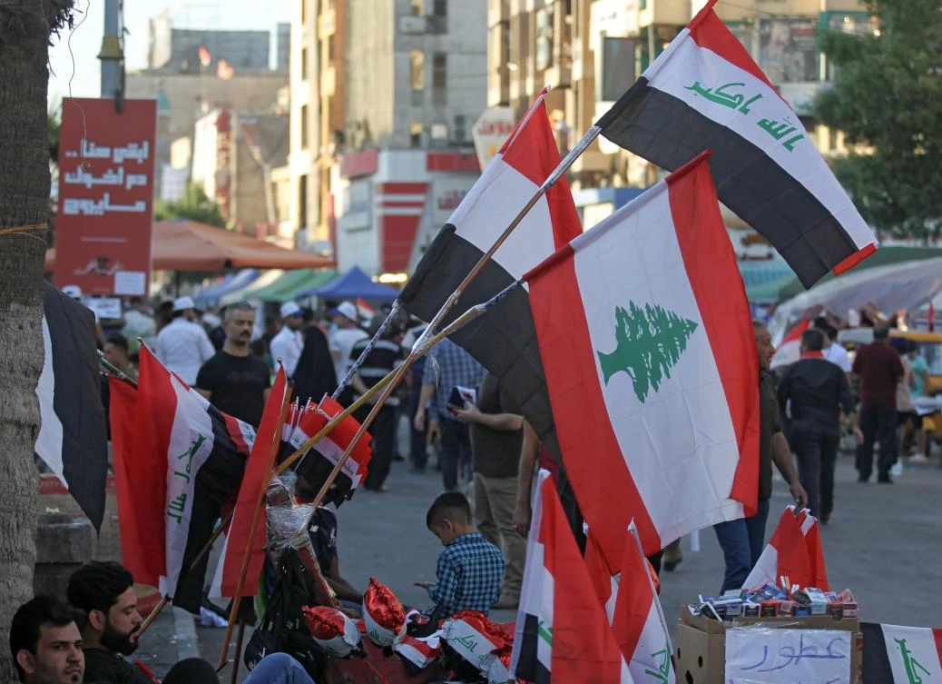 A picture taken on November 8, 2019, shows Iraq's and Lebanon's flags displayed for sale at a street vendor's stall in the Iraqi capital Baghdad. (AFP)