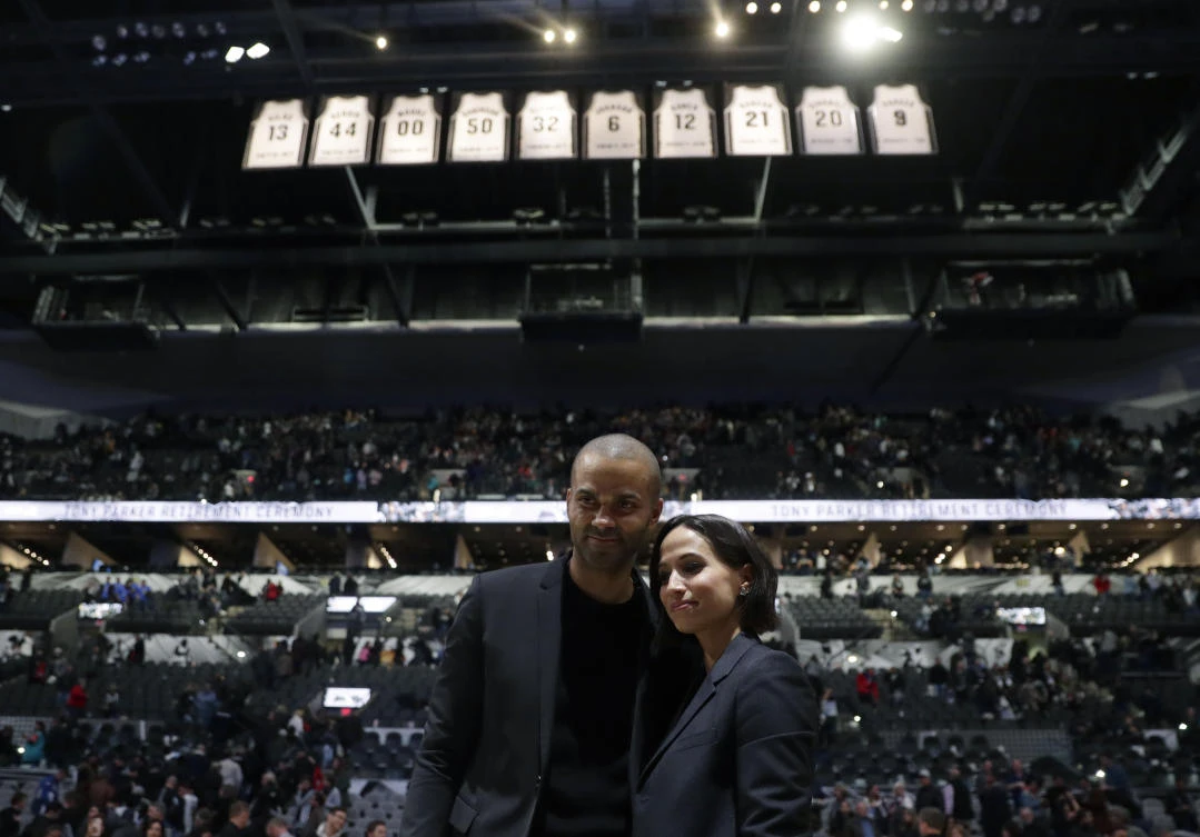 Former San Antonio Spurs guard Tony Parker, left, with his wife Axelle Francine-Parker poses under his jersey during his retirement ceremony in San Antonio on Monday, Nov. 11, 2019. (AP)