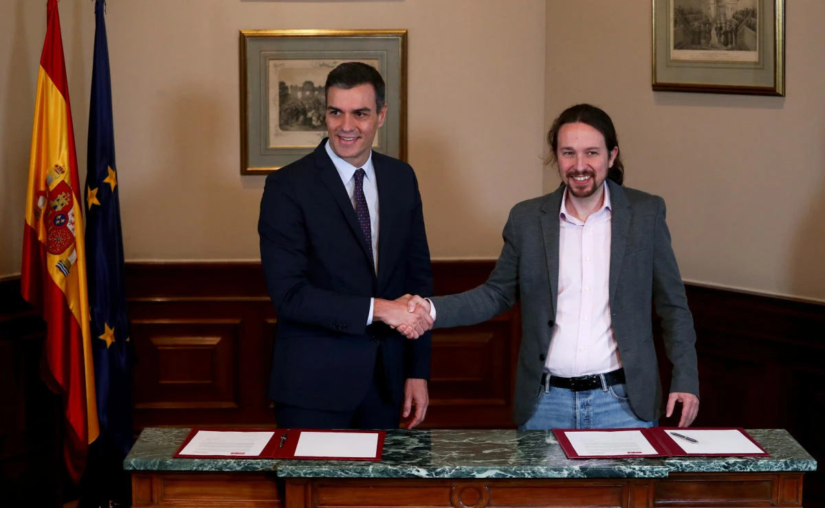 Spanish acting Prime Minister Pedro Sanchez and Unidas Podemos leader Pablo Iglesias shake hands during a news conference at Spain's Parliament in Madrid, Spain, November 12, 2019. (Reuters)