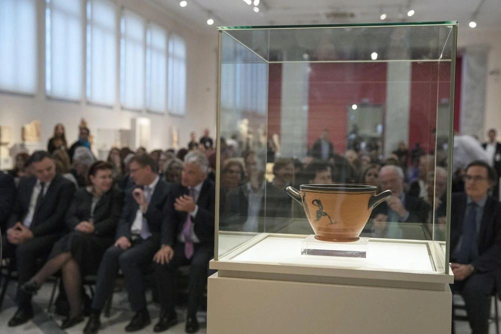 An ancient Greek drinking cup decorated with runners, which was one of the awards presented to Spyros Louis, the Greek winner of the Marathon in the 1896 first modern Olympic Games in Athens, is seen at the National Archaeological Museum in Athens on Nov. 13, 2019. (AP Photo/Petros Giannakouris)