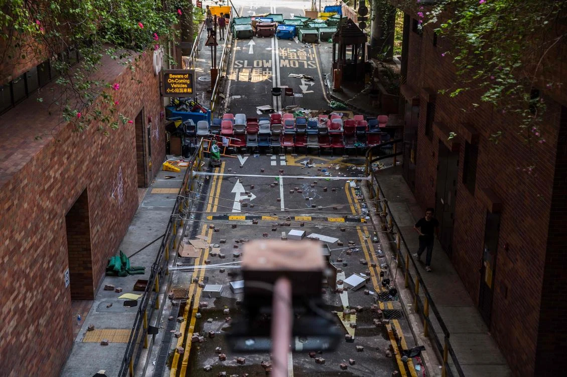 A man walks past an entrance to The Hong Kong Polytechnic University that has been barricaded by students and protesters on November 14, 2019. (File/AFP)